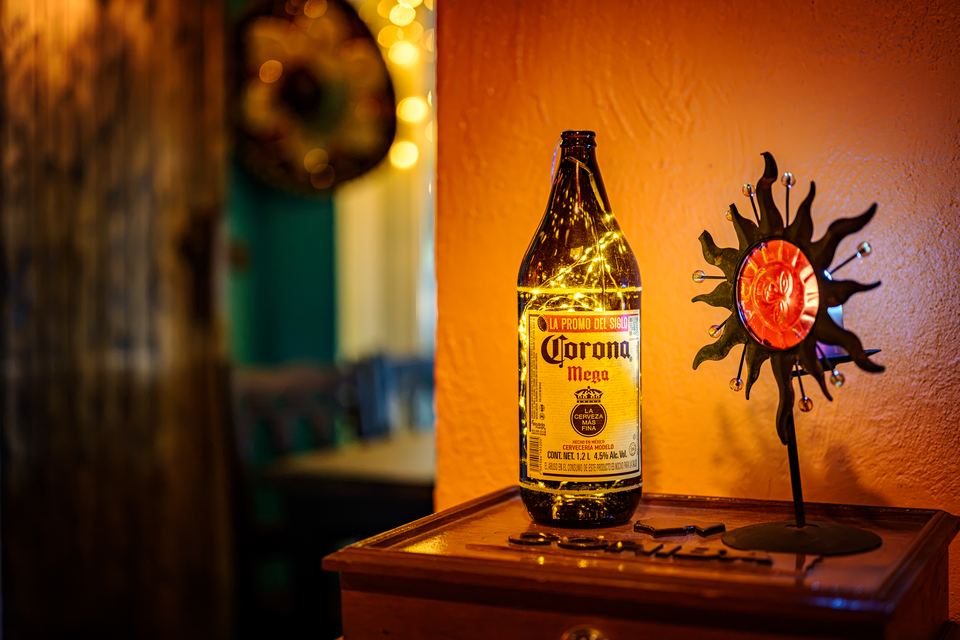 Corona-Flasche und Sonnen-Ornament auf dem Tisch
